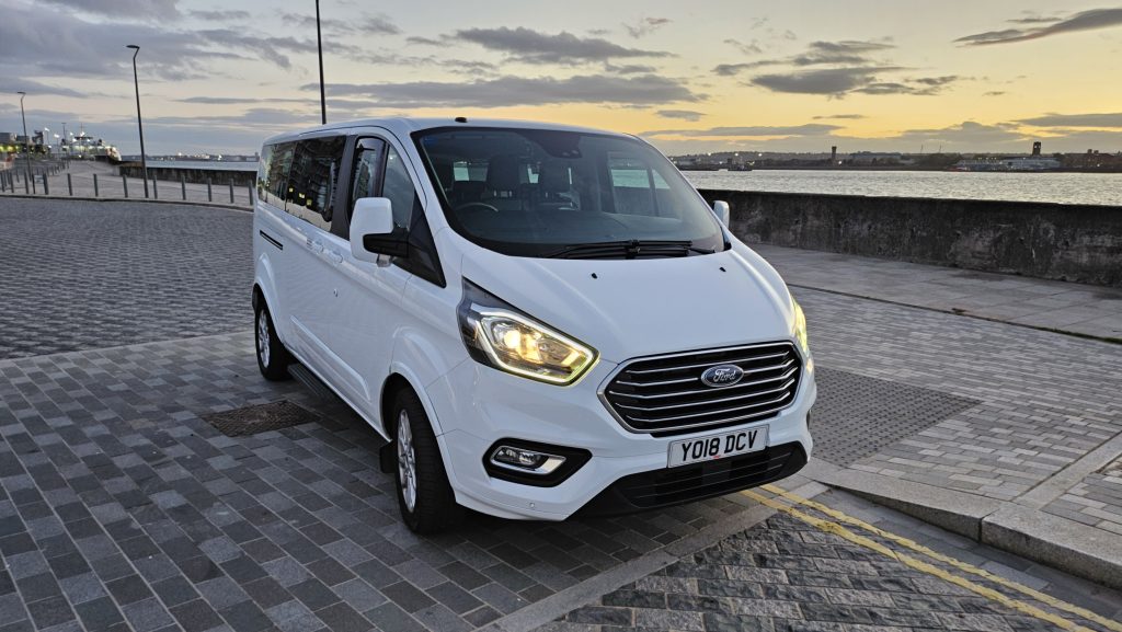 white minibus near the river mersey